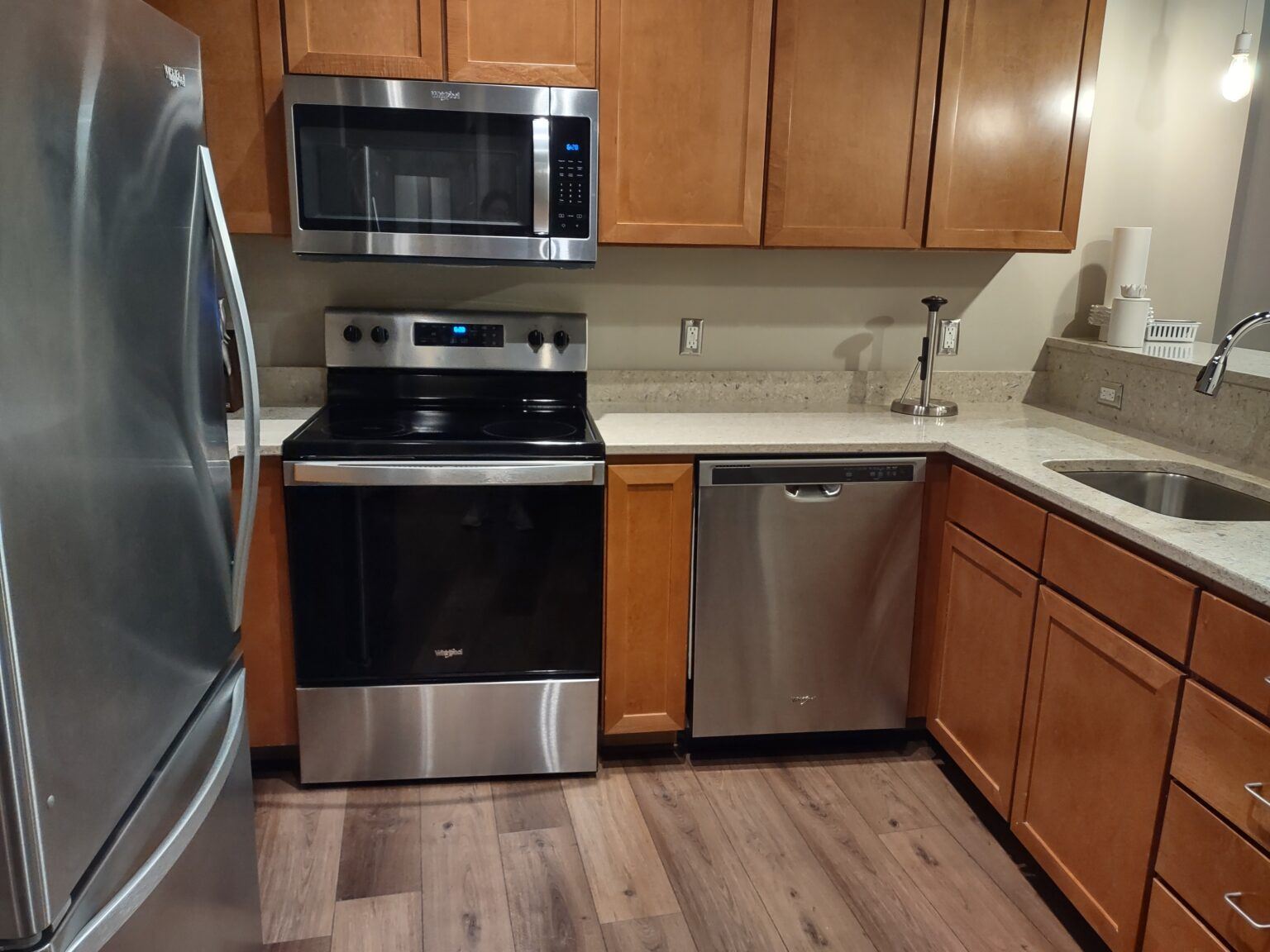 Clean kitchen with stainless steel appliances and wood cabinets after a house cleaning visit