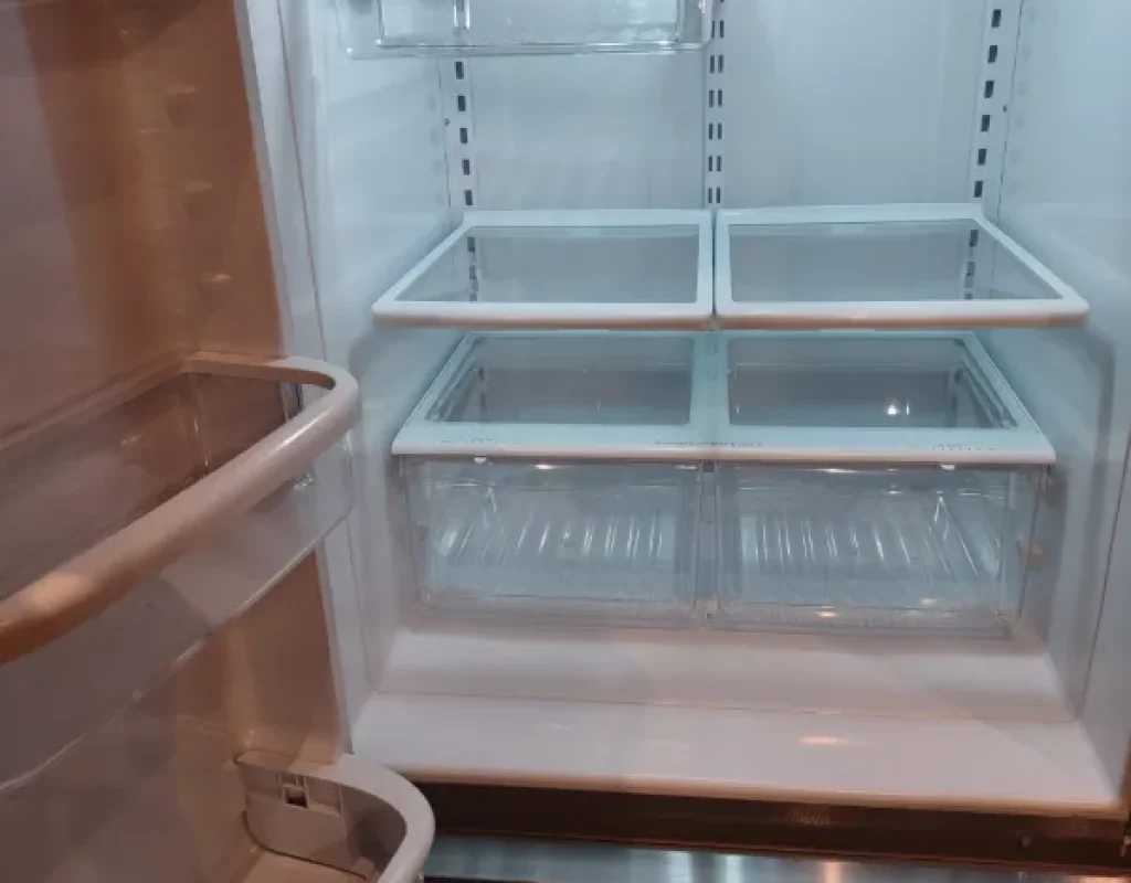 Empty refrigerator interior with clean glass shelves and drawers, an add-on task for move out cleaning in Millard, NE.